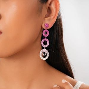 Detail of pink and white gradient geometric drop earrings with crystals on a model