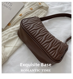 Detail of wave quilted pattern and smooth stitching on brown leather handbag base