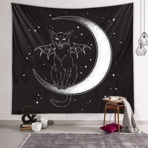 Detail of a gothic black cat and crescent moon tapestry hanging on a white brick wall