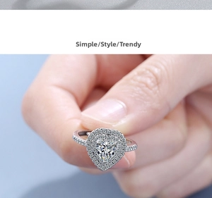 Macro shot of silver heart-shaped halo ring with side accent diamonds on band