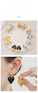 Polished double heart stud earrings in gold and silver finish on white porcelain tray
