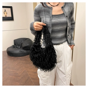 Detail of black faux fur shoulder bag with soft fringe texture and casual autumn style
