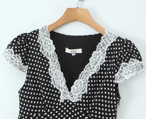 Détail de la dentelle blanche sur une robe rétro à pois avec décolleté en V, taille S