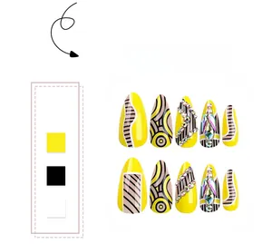 Detail view of yellow and black press-on nails with rainbow rhinestones and geometric art