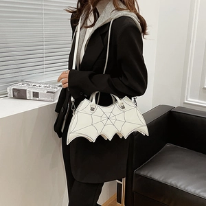 Detailed shot of white bat-wing bag with spiderweb stitching and skull hardware on model