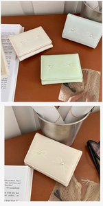 Detail of short wallets with bow and pearl accents in cream, green, and blue colors