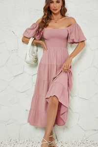 Détail d'une robe rose à épaules dénudées avec manches bouffantes et jupe à volants