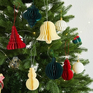 Christmas honeycomb paper ornaments featuring red trees and beige snowmen on a green tree