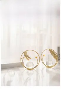 Detailed view of golden iron butterfly and crystal ball ornament on white books