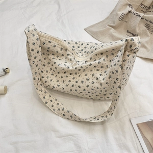 Detailed close-up of blue floral print on canvas tote bag with white zipper closure