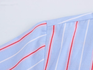 Macro detail of high-quality striped fabric texture and precise stitching on shirt shoulder