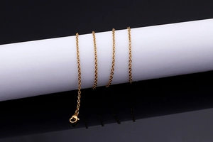 Macro view of gold chain necklace showing lobster clasp detail and link texture on display