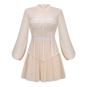 Detail of apricot puff sleeve mesh dress featuring polka dots and delicate lace textures