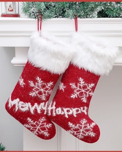 Detail of red knitted Christmas stockings with snowflake patterns and plush cuff on a mantle