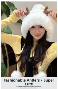 Detailed view of plush ivory winter hat featuring brown antlers and soft faux fur texture