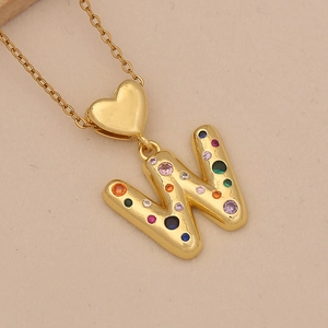Macro shot of gold necklace with letter W pendant and colorful zircon heart buckle