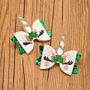 Detail of glitter unicorn bows hair clips with green clover pattern for St. Patrick Day