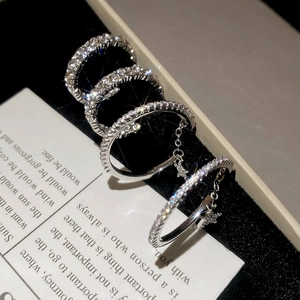 Macro shot of silver star rings with zircons on black velvet showing fine details