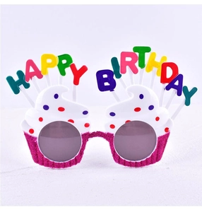 Close-up of birthday party glasses with pink glitter cupcake frames and Happy Birthday text