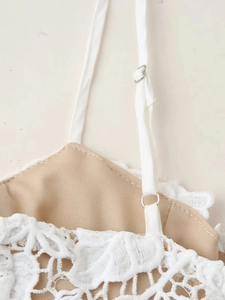 Détail des bretelles réglables avec boucles métalliques sur la robe en dentelle