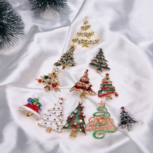 Detailed view of assorted Christmas tree and hat brooches with rhinestones and enamel