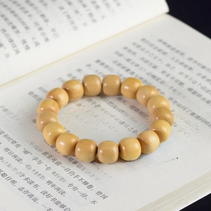Macro shot of sandalwood barrel beads bracelet on an open book for a Zen aesthetic