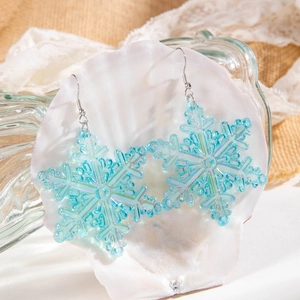 Close-up of snowflake earrings in translucent light blue resin with iridescent finish