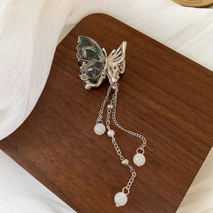 Détail de la pince à cheveux papillon argentée avec pampilles de perles et reflets