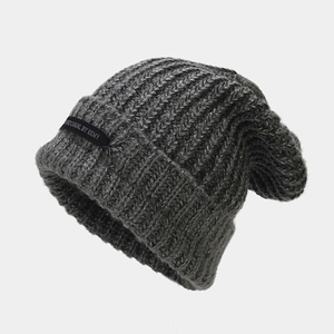 Detalle de la textura de punto y la etiqueta de un gorro de invierno en gris oscuro