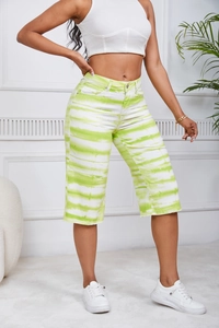 Detail view of high-waist tie-dye denim shorts in green and white casual style