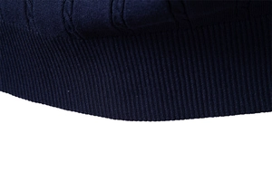 Makrodetail der dunkelblauen Strickweste mit Zopfmuster und gerippter Saumstruktur