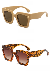 Close-up of square sunglasses in tea brown and tortoiseshell frames with gold hinges