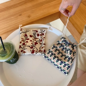 Detalle de bolsas con cordón de algodón con flores para guardar objetos pequeños