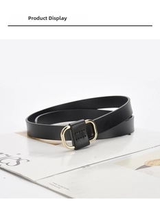 Detail of minimalist black leather belt featuring a golden D-ring buckle and reinforced stitching
