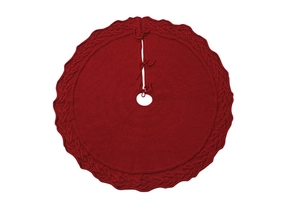 Detail of red knitted Christmas tree skirt with cable knit patterns and tie closures