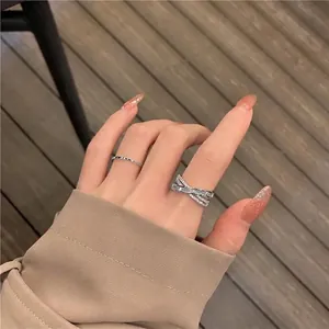 Luxuriöses silbernes X-Ring-Set mit glitzernden Zirkonia an der Frauenhand