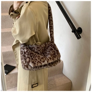 Detalle de la textura de felpa del bolso de leopardo con correa larga para el hombro