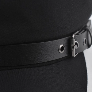 Detailed macro view of the black cotton military cap with leather strap and metal buckle