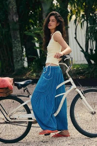 Detail of blue striped wide-leg trousers with white drawstring on a female fashion model