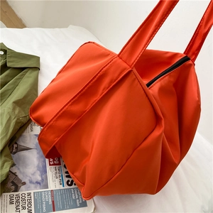 Bright orange large capacity oxford cloth sports bag with black metal zipper on white bedding