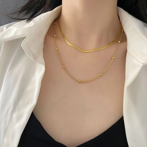 Double-layered gold titanium steel necklace featuring a sleek snake chain and bead accents
