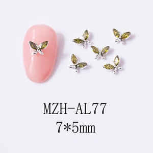 Macro view of 7x5mm olive green zircon butterfly nail art charms with silver alloy base