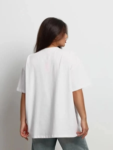 Πίσω όψη λευκού oversize βαμβακερού t-shirt με πεσμένους ώμους και χαλαρή γραμμή εφαρμογής