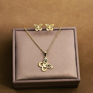 Detailed view of hollow butterfly necklace and earrings set in golden stainless steel