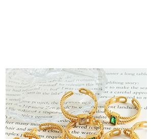 Detailed shot of vintage gold rings set with emerald green and clear square gemstones