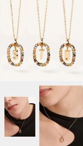 Detailed view of gold letter pendants S, T, U with colorful crystals on model