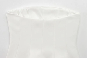 Detail view of white strapless top featuring hidden side zipper and premium stitching
