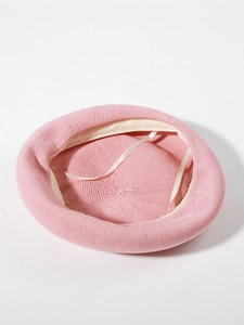 Detail view of pink knitted beret featuring interior lining and adjustable ribbon drawstring