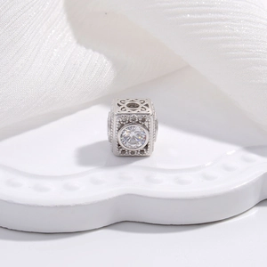 Square silver charm bead with hollow patterns and sparkling round zircon centerpiece