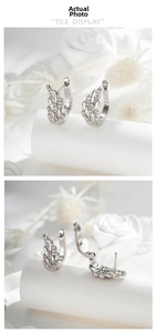Detailed view of silver angel wing earrings with cubic zirconia and hoop closure